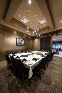 Side view of the sophisticated meeting room, showing the arrangement of chairs, modern ceiling lighting, and the accent wall with a gold metallic finish.