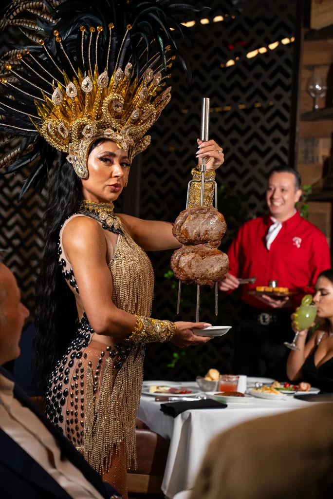 A dancer in an elaborate Brazilian carnival costume, holding a skewer of grilled meat, capturing a lively and festive ambiance.