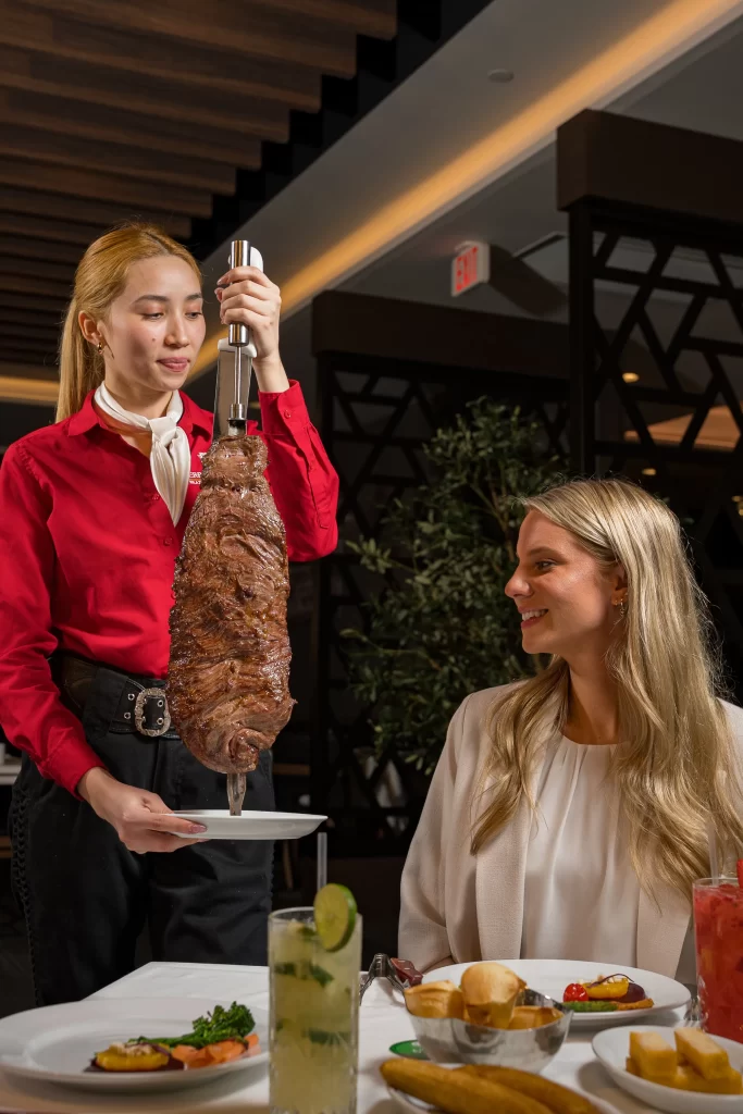Exterior view of a Terra Gaucha Steakhouse with parked cars in front.