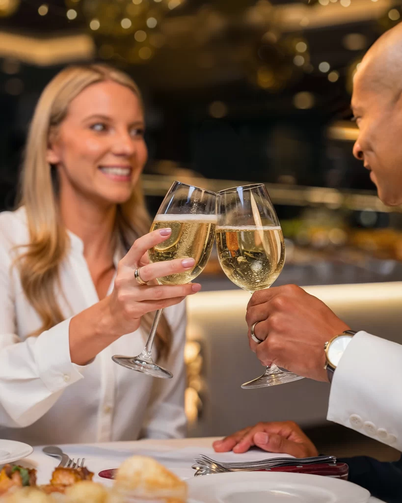 Elegant couple toasting with white wine in a sophisticated restaurant atmosphere